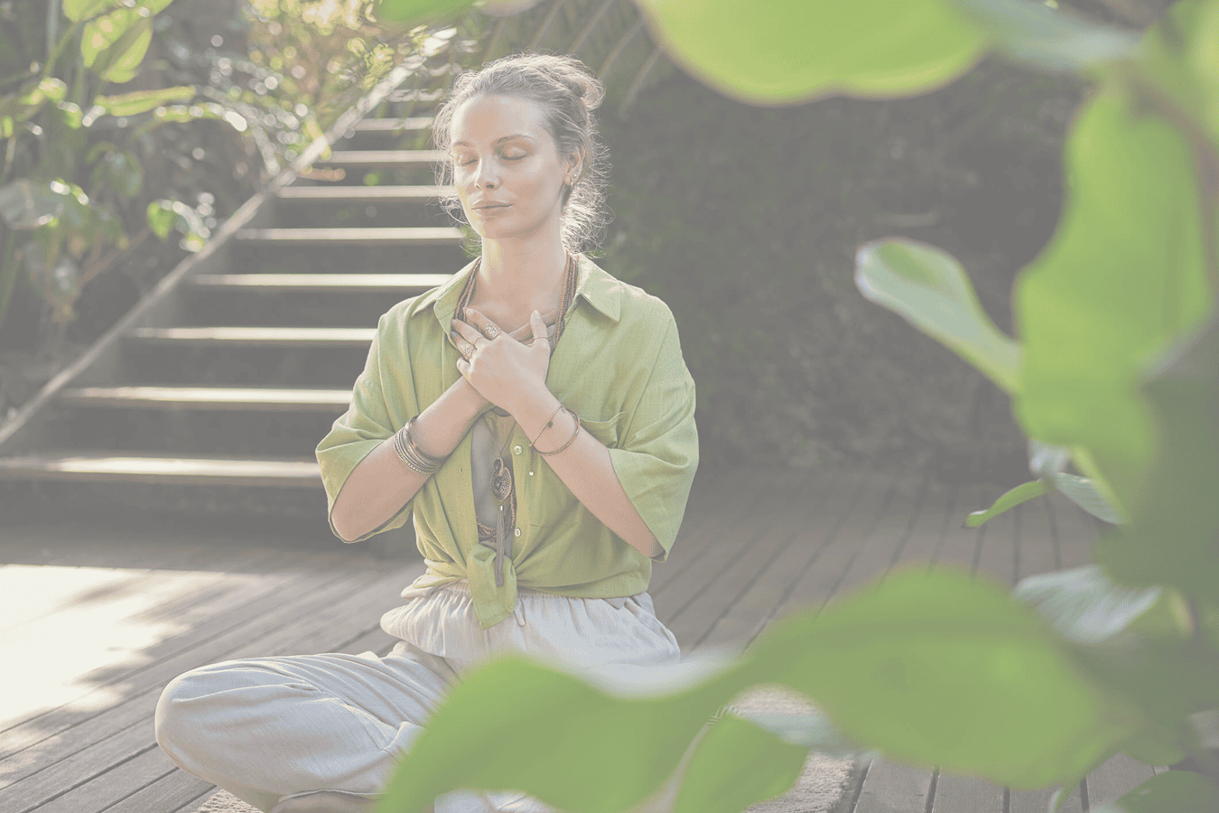 Woman meditating outdoors on wooden deck